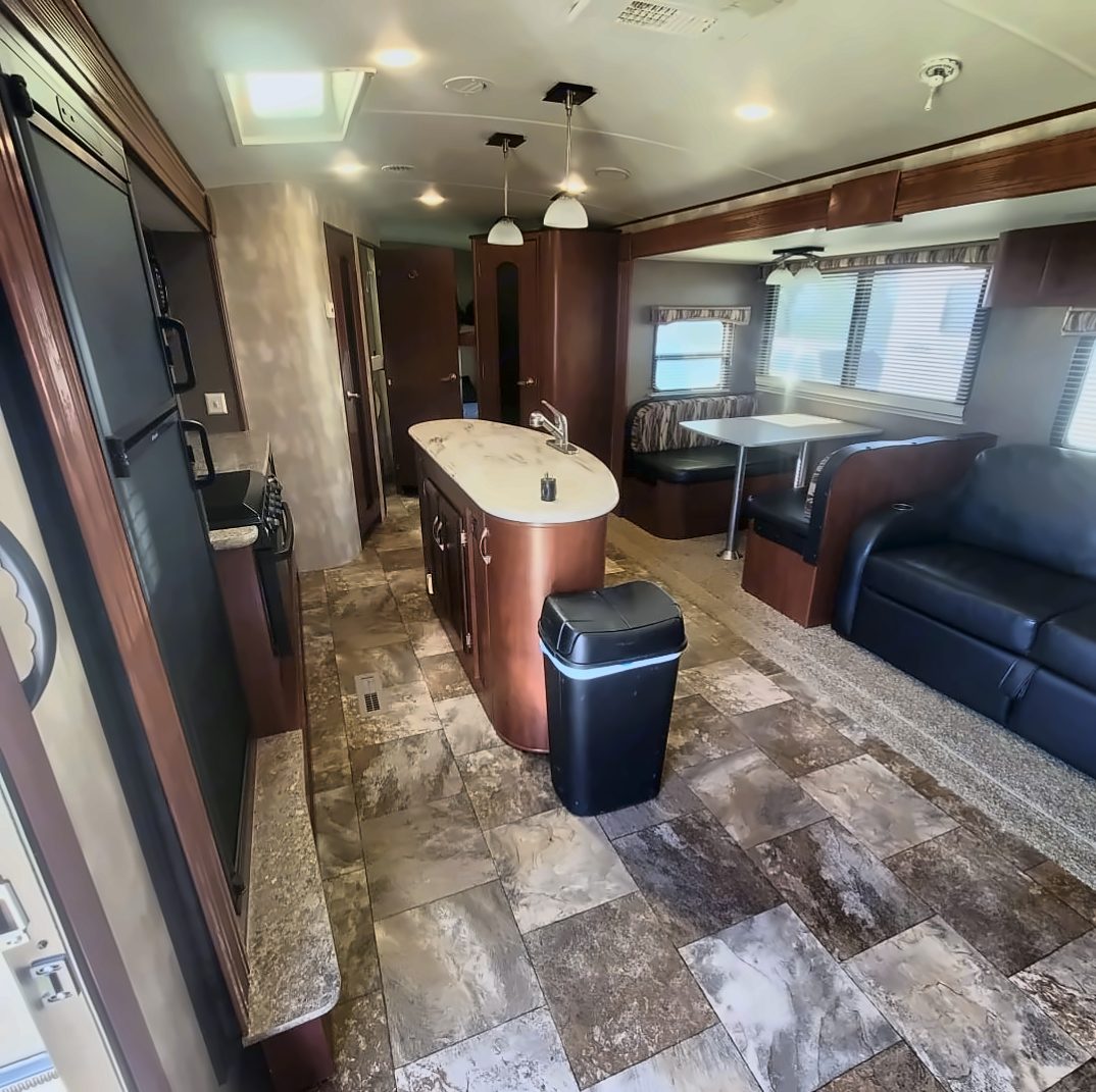 Inside the trailer: kitchen island, dinette, and sofa in the slide-out